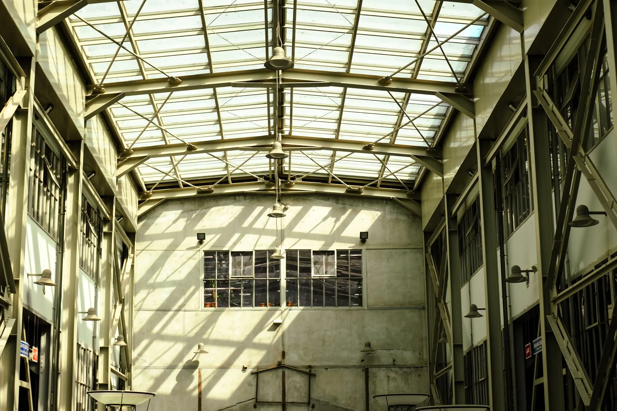 A large warehouse interior lit from a glazed roof and overhead fittings