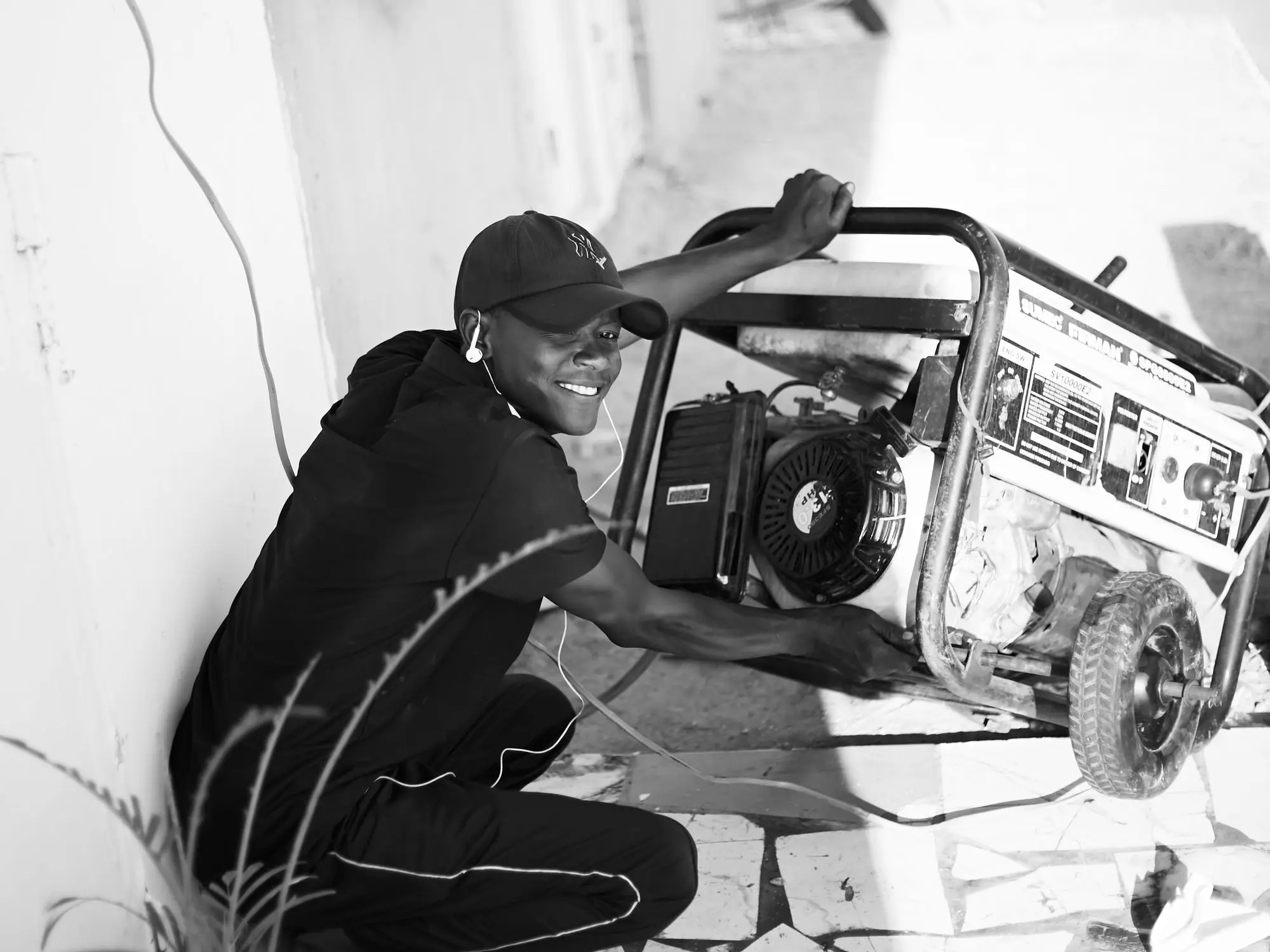 A person starting a portable generator outdoors
