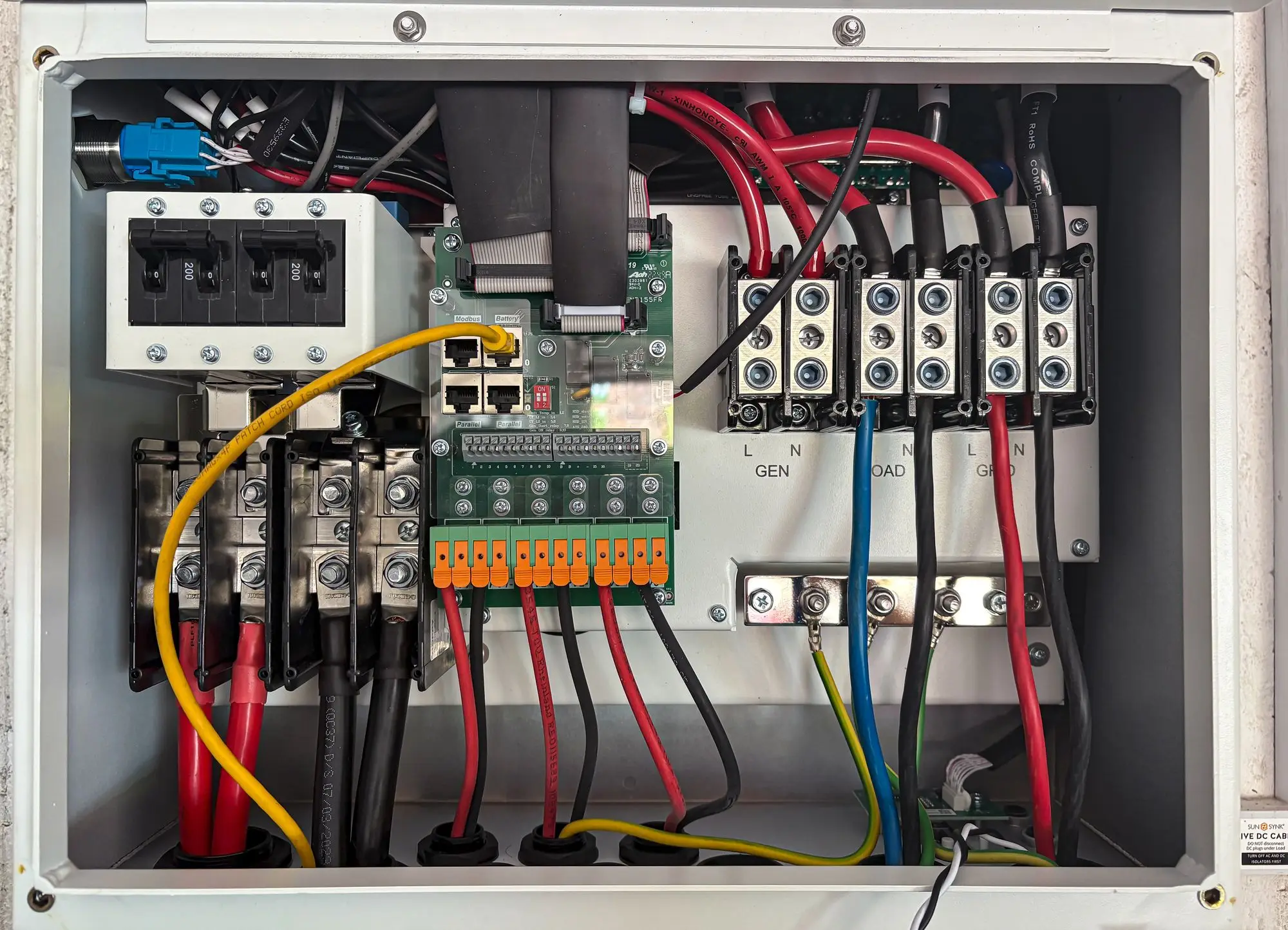 The inside of an electrical control panel showing rows of connected components